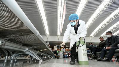 A worker disinfects the seats at a railway station in Nanchang City, Jiangxi province. EPA