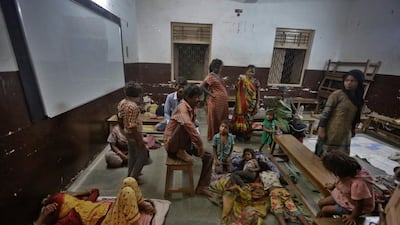 People evacuated from the coastal areas take shelter at a school in Veraval, Gujarat, India. AP Photo