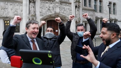 Uber drivers of the App Drivers & Couriers Union celebrate as they listen to the court decision on a tablet computer outside the Supreme Court in London. AP Photo