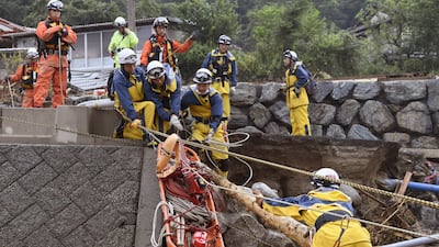 Firefighters cross a swollen river during a search operation following the flooding caused by heavy rain in Asakura, Fukuoka prefecture, southwestern Japan, Saturday, July 8, 2017. The southern island of Kyushu suffered heavy rain after Typhoon Nanmadol swept across Japan earlier in the week, dumping large amounts of rain that damaged homes, roads and rice fields. (Junko Ozaki/Kyodo News via AP)