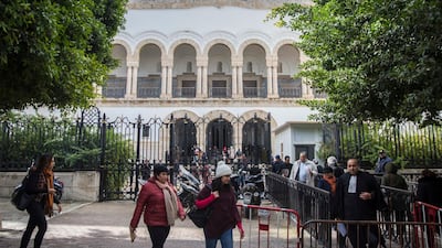 People walk in front of the Tunis Palace of Justice in Tunis. More than 40 people have been summoned to face trial over Tunisia's deadliest attack in a Mediterranean resort in 2015. AP