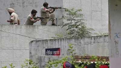 Indian police take position as their colleagues look on during a gunfight in the town of Dinanagar in the Punjab district of Gurdaspur on July 27, 2015. Munish Sharma/Reuters