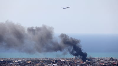 A Middle East Airlines aircraft takes off from the airport in Beirut as smoke rises from the site of an Israeli air strike, on March 17. AFP