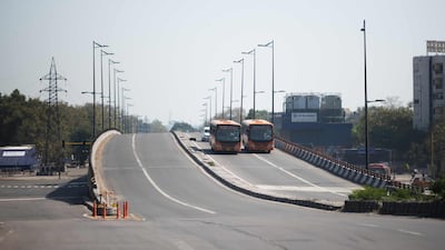 Two buses are driven on a deserted street during the first day of a 21-day government-imposed nationwide lockdown, in New Delhi. AFP
