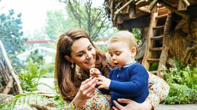 The Duchess of Cambridge plays with her son, Prince Louis, in the garden she has co-designed for the RHS Chelsea Flower Show in London. Matt Porteous / Kensington Palace via AP