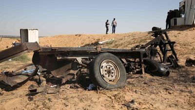 Palestinian men walk at the site of an explosion east of Rafah in the southern Gaza Strip, on April 14, 2018. Said Khatib / AFP