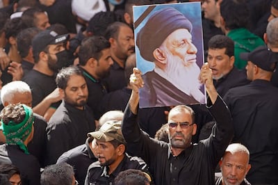 An Iraqi mourner carries a poster of Grand Ayatollah Mohammed Saeed Al Hakim during his funeral. AFP
