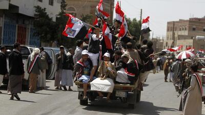 Shiite Houthi militants waving national flags ride in the back of a patrol vehicle after a rally in Sanaa on Friday. Mohammed Al Sayaghi / Reuters