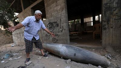 A Palestinian man reacts as he looks at an unexploded bomb dropped by an Israeli F-16 warplane on Gaza City's Rimal neighbourhood on May 18. AFP