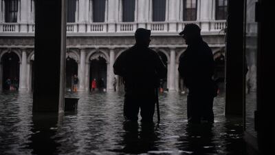 Persons stand in floods in Venice, in the morning of November 17. Filippo Monteforte / AFP