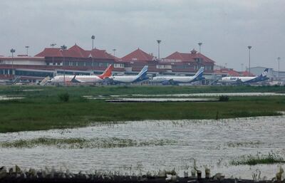 Airplanes are pictured as they are parked next to flood waters on the tarmac of the international airport in Kochi in southern Kerala state on August 9, 2019. Floods that have killed more than 20 people forced the closure of Kochi international airport on August 9 as the south Indian state of Kerala confronted a second straight year of crisis level downpours. / AFP / STR