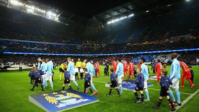 Manchester City and Sevilla players walk out at the start of the Champions League match on Wednesday night at the Etihad Stadium. Richard Heathcote / Getty Images