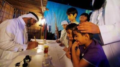 Children have their names written in calligraphy during the Dar Al Ber Society's 8th Annual Orphans Ceremony at the Dubai World Trade Center(DWTC). Satish Kumar / The National