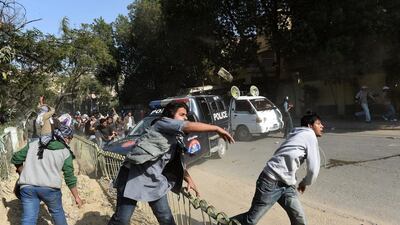 Pakistani activists of the Jamaat-e-Islami religious party throw stones toward riot police during a protest against the printing of satirical sketches of the Prophet Muhammad by French magazine Charlie Hebdo in Karachi on January 16. AFP Photo