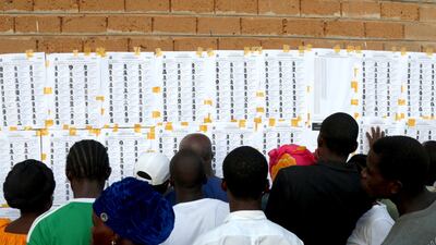 Liberian citizens search for their names before casting their vote in the presidential and general election, outside Monrovia. EPA
