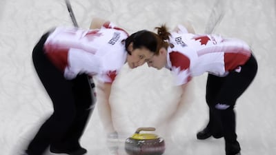 Canada’s s Jill Officer, left, and Dawn McEwen sweep ahead of the rock during the women's curling gold medal game against Sweden on February 20, 2014. Robert F. Bukaty / AP Photo