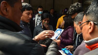 Family members of a plane crash victim hold pictures of their loved ones outside a morgue at the Teaching Hospital in Kathmandu on March 13, 2018, a day after the deadly crash of a US-Bangla Airlines plane at the international airport. Prakash Mathema / AFP
