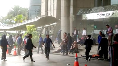 This photo received from Amailia Putri Hasniawati via WhatApp shows people running for cover at the entrance of Indonesia's stock exchange. Amailia Putri Hasniawati / AFP