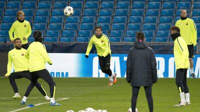 Barcelona's Lionel Messi eyes the ball during Monday's Champions League training session in Manchester. Oli Scarff / AFP
