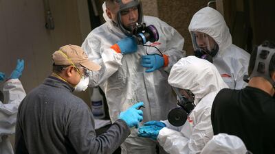 A cleaning crew disinfects and removes protective clothing after exiting the Life Care Center on March 11, 2020 in Kirkland, Washington. Getty Images/AFP