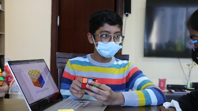 Manan Chandak, 12, teaches children how to solve Rubik's Cubes. Nilanjana Gupta / The National