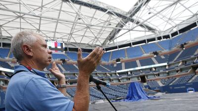 Sound technician Nick Scarmozzino tests the sound system in a tarp-covered Arthur Ashe Stadium after rain postponed play on Thursday. Kathy Willens / AP