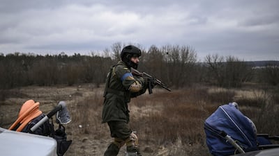 A Ukrainian serviceman walks carefully with his weapon in the city of Irpin, near Kyiv. AFP