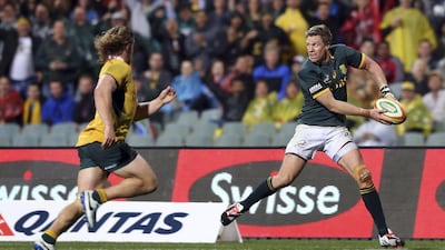 Jean de Villiers of South Africa's Springboks passes the ball under pressure from Michael Hooper, left, of Australia. De Villiers is poised to play in his 100th Test match on Saturday. Reuters photo