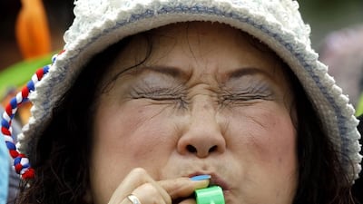 A Thai anti-government protester blows a whistle on February 20, 2014, during a rally to shut down the Shinawatra Tower III office building in Bangkok, Thailand. Thousands of protesters massed outside the building, which houses firms partly owned by the family of caretaker prime minister Yingluck Shinawatra. They berated the Shinawatras for corruption and deception, but stopped short of invading the building in a renewed bid to force her resignation. Rungroj Yongrit / EPA