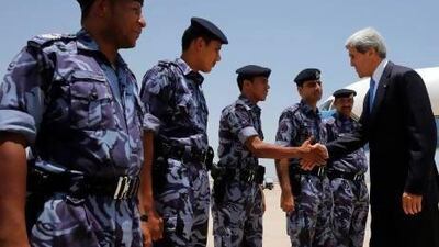 US secretary of state John Kerry meets with security personnel before boarding his plane in Muscat.