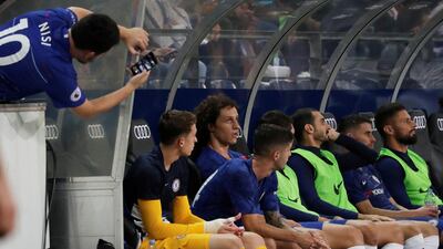 A Chelsea fan takes a picture of their substitutes on the bench. Reuters