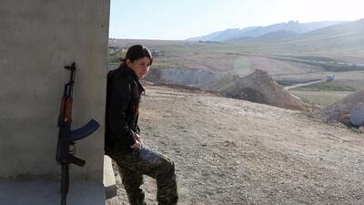 A female fighter stands outside the base.