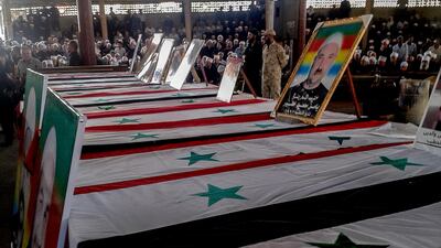 Druze clerics and citizens sit next to the coffins of those who died during a serioes of ISIS attacks. EPA