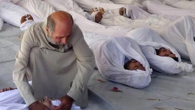 A Syrian man mourns over a dead body after an alleged poisonous gas attack fired by regime forces, according to activists, in Douma town, Damascus. Media Office Of Douma City / AP Photo