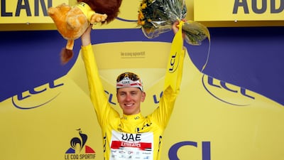 UAE Team Emirates rider Tadej Pogacar on the podium after retaining the yellow jersey.