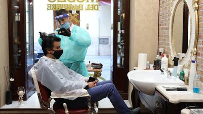 A hairdresser, wearing a protective face mask, works in a barber shop in Rome, Italy. Bloomberg