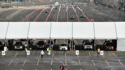 Cars make their way through lines of cones as they arrive for a UCHealth drive-up mass Covid-19 vaccination event in the parking lots of Coors Field in Denver, Colorado. The Denver Post via AP
