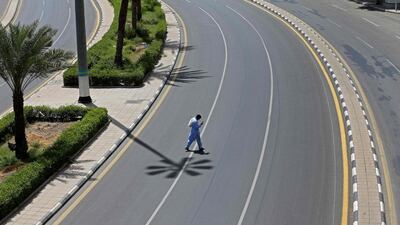 A man checks his phone as he crosses an empty street in Saudi Arabia's holy city of Makkah on April 3, 2020. AFP