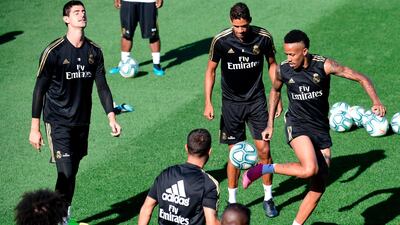 Eder Militao, right, Raphael Varane, centre, and Thibaut Courtois take part in training session. AFP