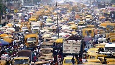 People struggle for space between buses and trucks in Lagos. Africa represents the world's third-largest market. Pius Utomi Ekpei / AFP