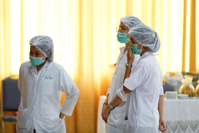 Hospital staff watch a press conference in which a Thai public health official reports the eight boys saved so far are in "high spirits" and that have strong immune systems because they are football players. Vincent Thian / AP