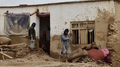 Afghan men clear debris and mud from a house in Laqiha village. AFP