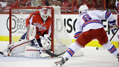 Washington Capitals goalie Braden Holtby, left, makes a save against New York Rangers right wing Darroll Powe. Evan Vucci / AP Photo