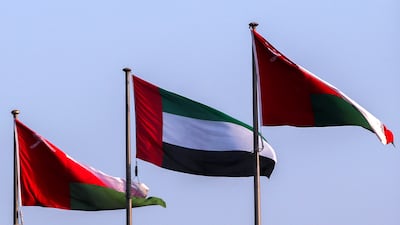 The UAE flag is raised beside the flag of Oman in Muscat, a day before the arrival of President Sheikh Mohamed. Victor Besa /The National