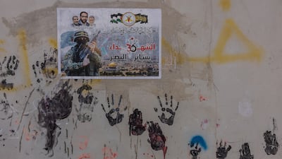 Paintings of children's hands and a poster of a resistance fighter in Jenin refugee camp in the northern part of the occupied West Bank
