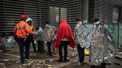 Anti-government protesters who asked for medical help are led away at Hong Kong Polytechnic University in Hong Kong. Getty Images