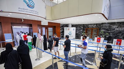 People queue as they wait their turn to receive a dose of COVID-19 coronavirus vaccine at the make-shift vaccination centre at the Kuwait International Fairground in the Mishref suburb south of Kuwait City. AFP