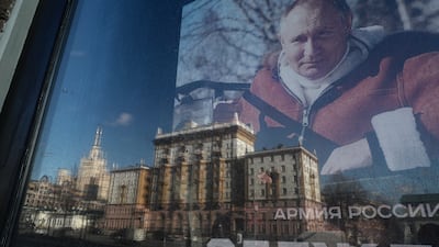 The US Embassy is reflected in a store window showing a photo of Russian President Vladimir Putin in Moscow on Monday. EPA
