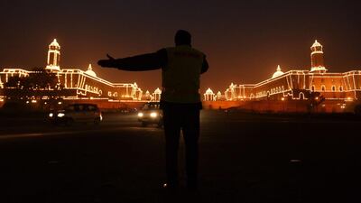 A policeman directs traffic in front of the Central Secretariat and Parliament buildings in New Delhi. Chandan Khanna / AFP