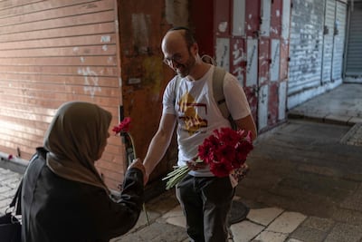 An Israeli left-wing activist hands a flower to a Palestinian woman. AFP